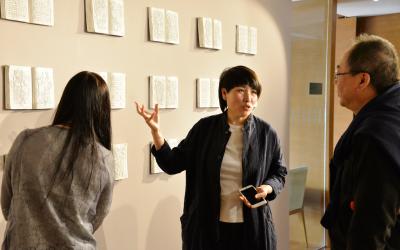 Artist Wen Fang speaks to visitors at the opening of her exhibition in the Steve Sun Gallery at the Center in Beijing