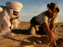 2 men digging for fossils in African Desert
