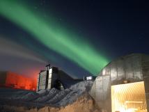 Aurora Lights hovering aboving metal buildings in Antarctica