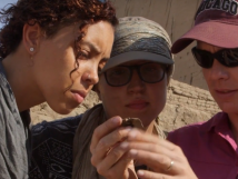 Three women looking at artifacts