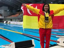 Swimmer holding a Malaysian national flag