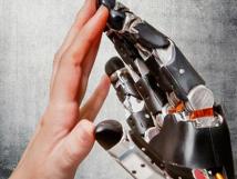 Photo of a robotic and human hand touching