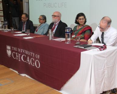 Multiple people seated at a table for a panel discussion