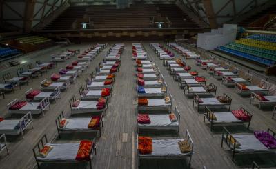 Workers prepare beds to set up a COVID-19 isolation center in Srinagar, India