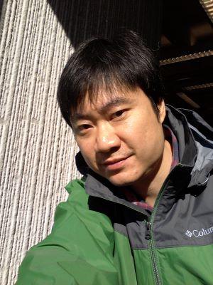 Headshot of GUO Weiqi in green coat against white background