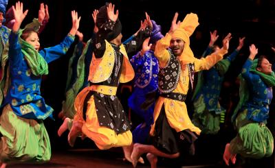 Students dressed in traditional clothes jumping in the air