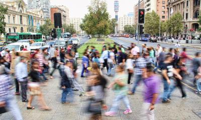 Many people walking across the street in a timelapse photo