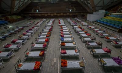 Workers prepare beds to set up a COVID-19 isolation center in Srinagar, India