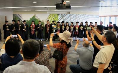 Family members take photos of their graduates