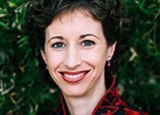 Woman wearing a black and red suit smiling for a picture