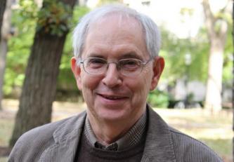 Man with glasses wearing a suit smiling for a picture